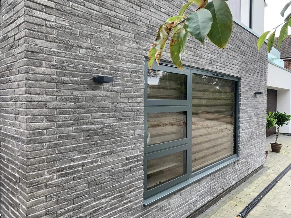 Šedý cihlový obklad Mura Brick na fasádě u okna
